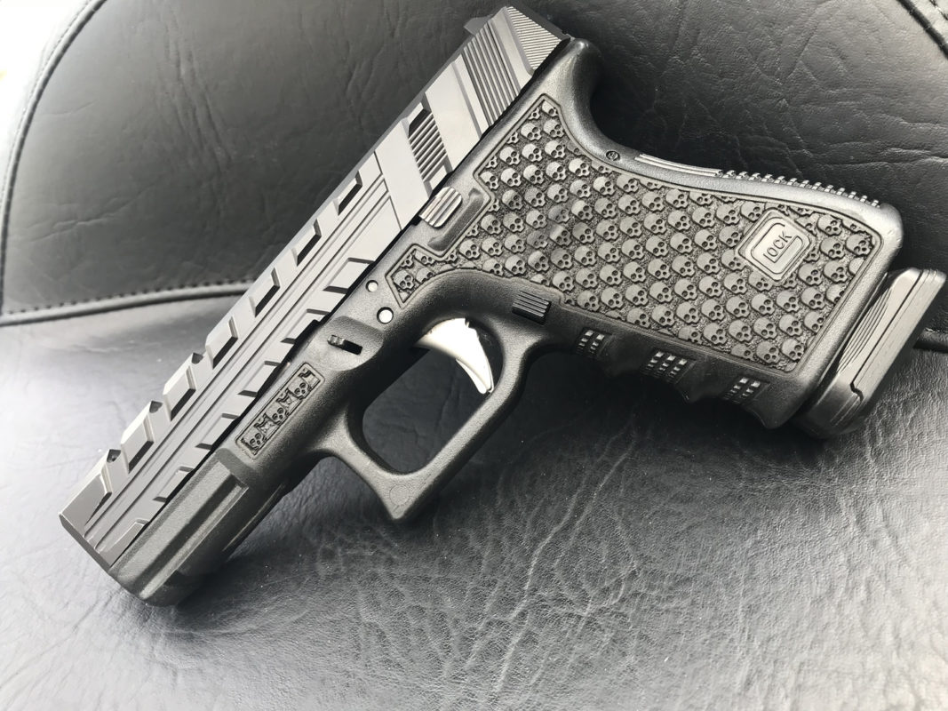 Image of custom Glock with slide cuts and laser stippling.